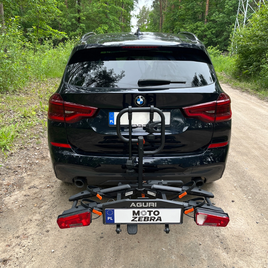 Dwa rowery na czarnej platformie Aguri zamontowanej na haku za ciemnym SUV-em